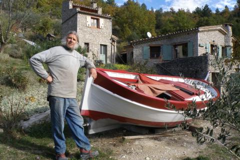 Bernard Naudin devant sa dernière barque en cours de restauration